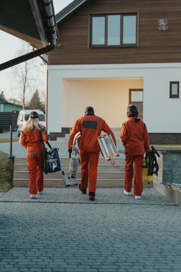 The Art of Drawing Readers In: Your attractive post title goes here Cleaning crew in red uniforms with equipment approaching a modern house exterior.